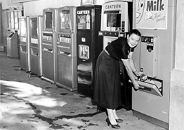 Eine Frau bedient einen Verkaufsautomaten 