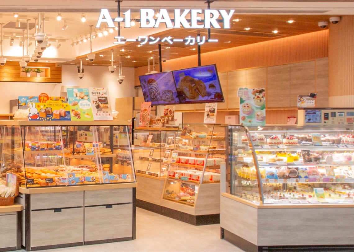Interior da A-1 Bakery, destacando vitrines com várias opções de produtos de panificação e confeitaria, ideal para amantes de doces e pães.