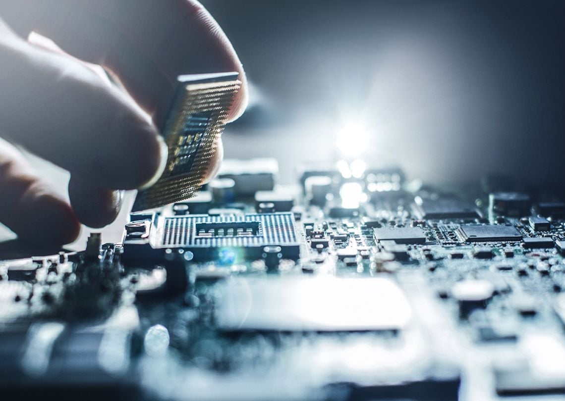 Pessoa instalando um processador de computador na placa-mãe, componentes eletrônicos visíveis em close-up, tecnologia avançada e eletrônica.