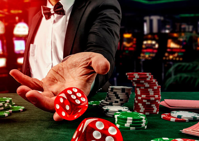 Jogador lança dados em mesa de cassino com fichas e cartas, destacando o setor de jogos, casas de apostas e soluções para manuseio de dinheiro.