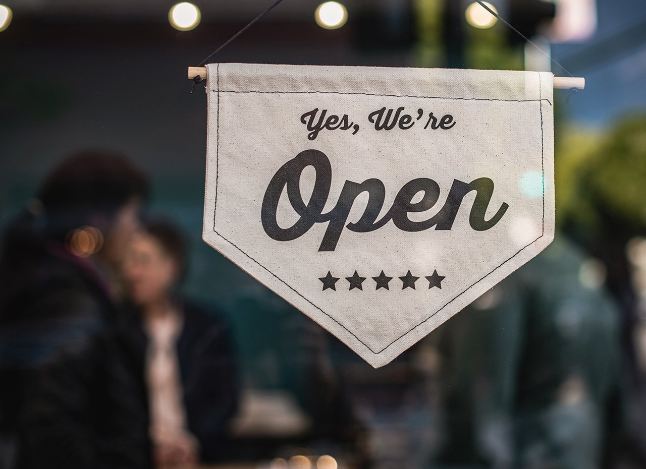 Ladenschild mit der Beschriftung 'Yes, we are open'