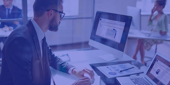 Homem de negócios trabalhando com planilhas e gráficos em escritório moderno, representando análise de dados e planejamento empresarial.