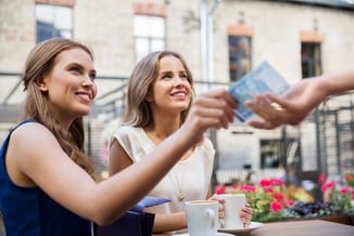 Zwei Frauen zahlen bar im Außencafé