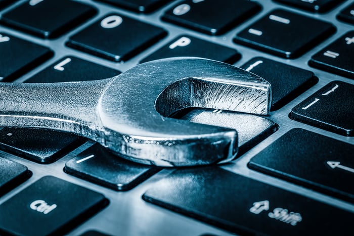 Chave de fenda colocada sobre um teclado de computador, simbolizando suporte técnico ou reparo em tecnologia.