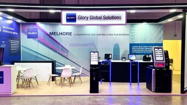 Stand da Glory Global Solutions apresentando soluções de automação para melhorar a experiência dos clientes e funcionários em eventos de tecnologia.