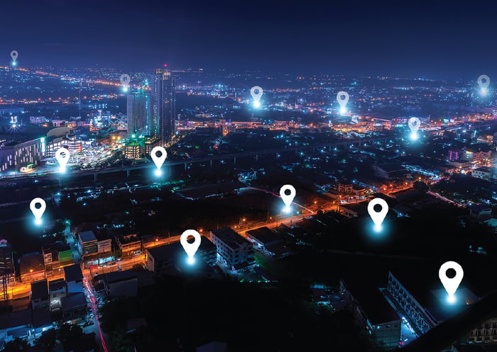 Mapa inteligente de uma cidade à noite com pontos de conexão iluminados representando dados de localização ou sensores conectados.